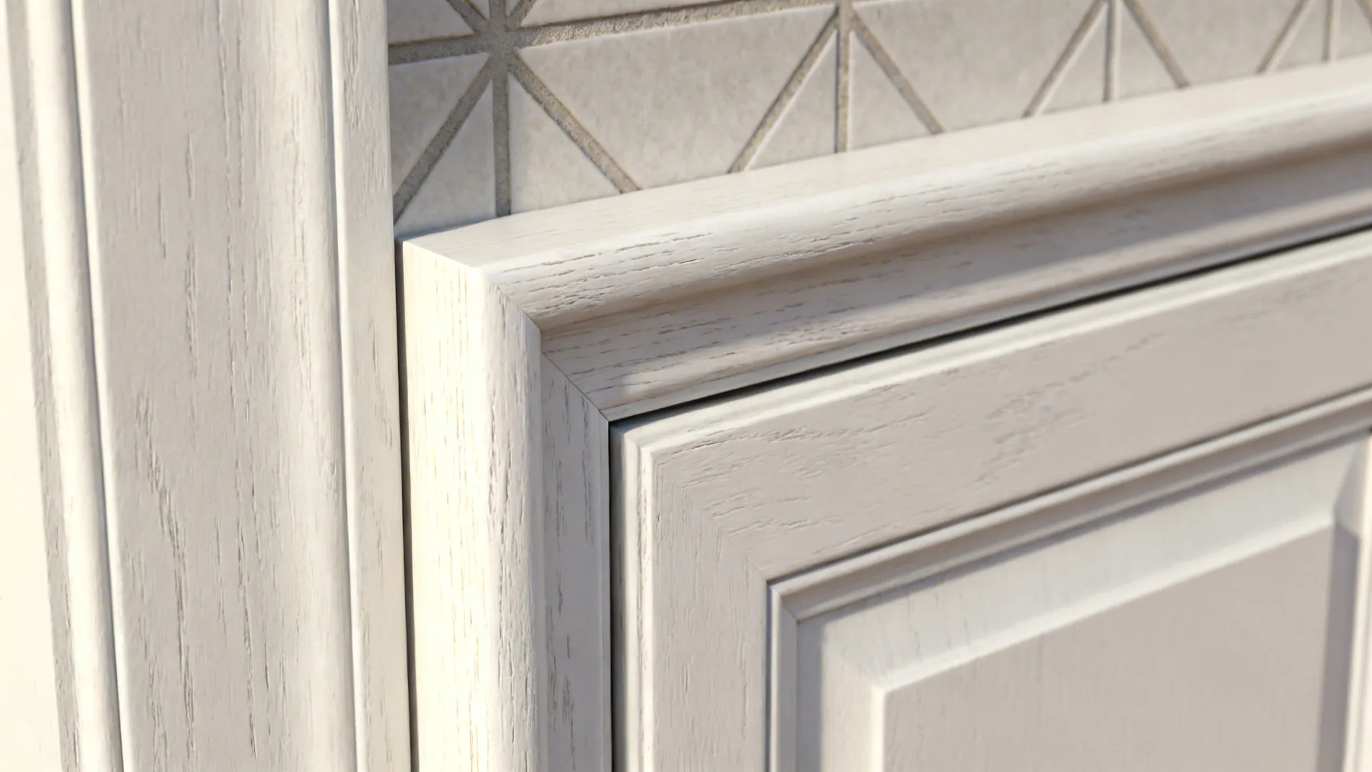 Close-up of white shaker cabinet door and patterned tile backsplash showing texture