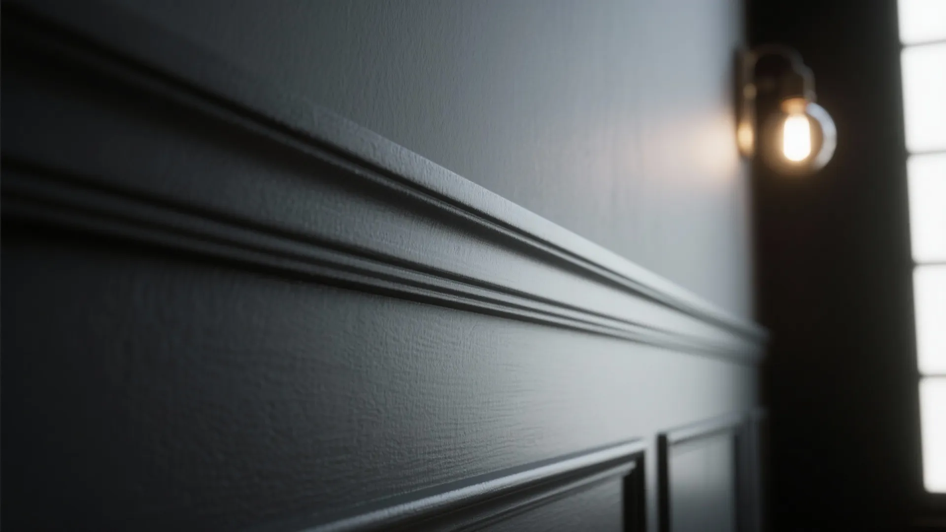 Close up of dark grey wall panel design with a warm light fixture and window
