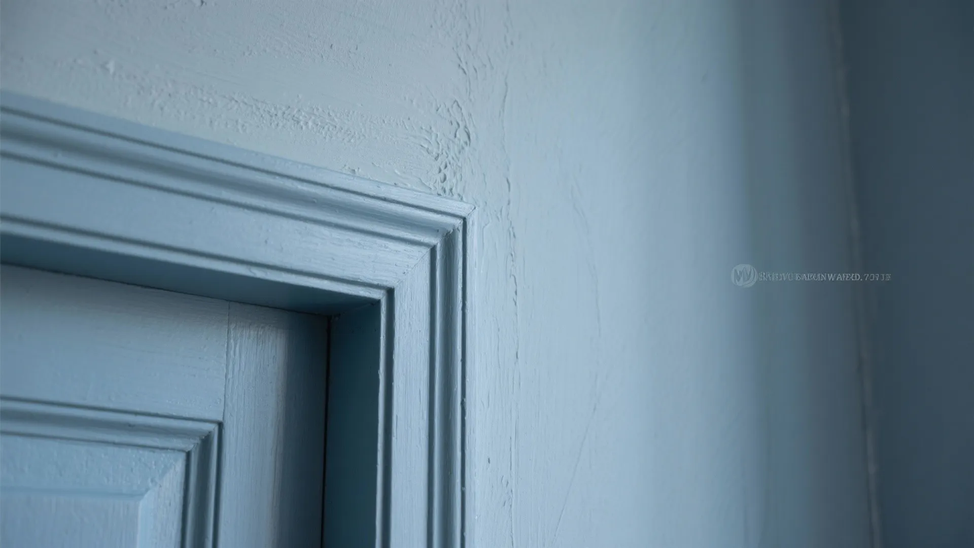 Close up view of a blue painted door frame and wall showing texture and clean lines
