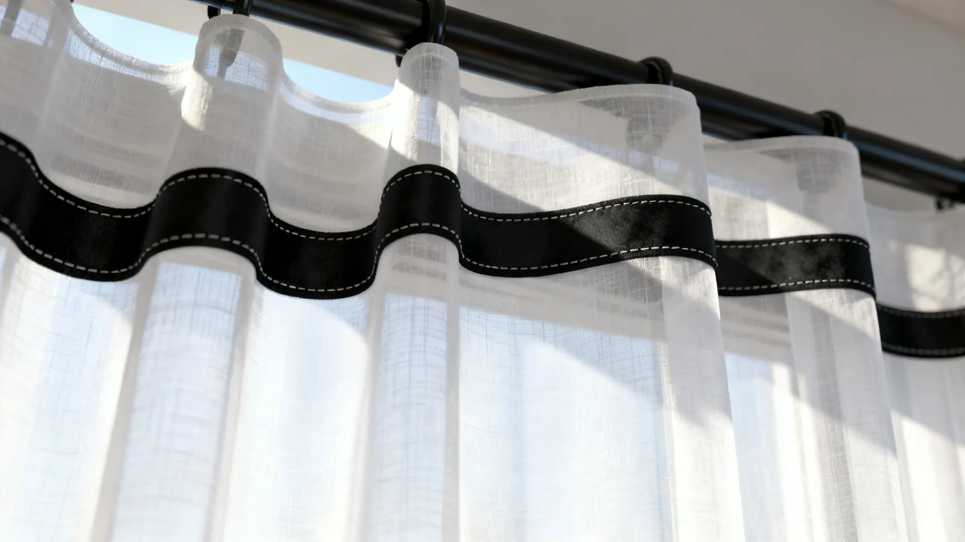 Macro view of sheer white curtain with a black trim and visible fabric texture.
