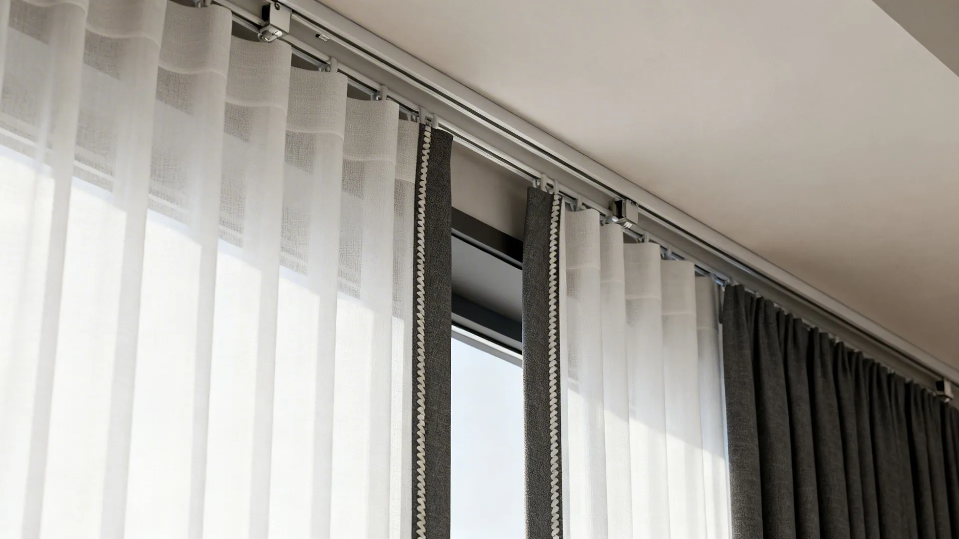 Close-up of ceiling-mounted double track with white sheer and charcoal blackout curtains.