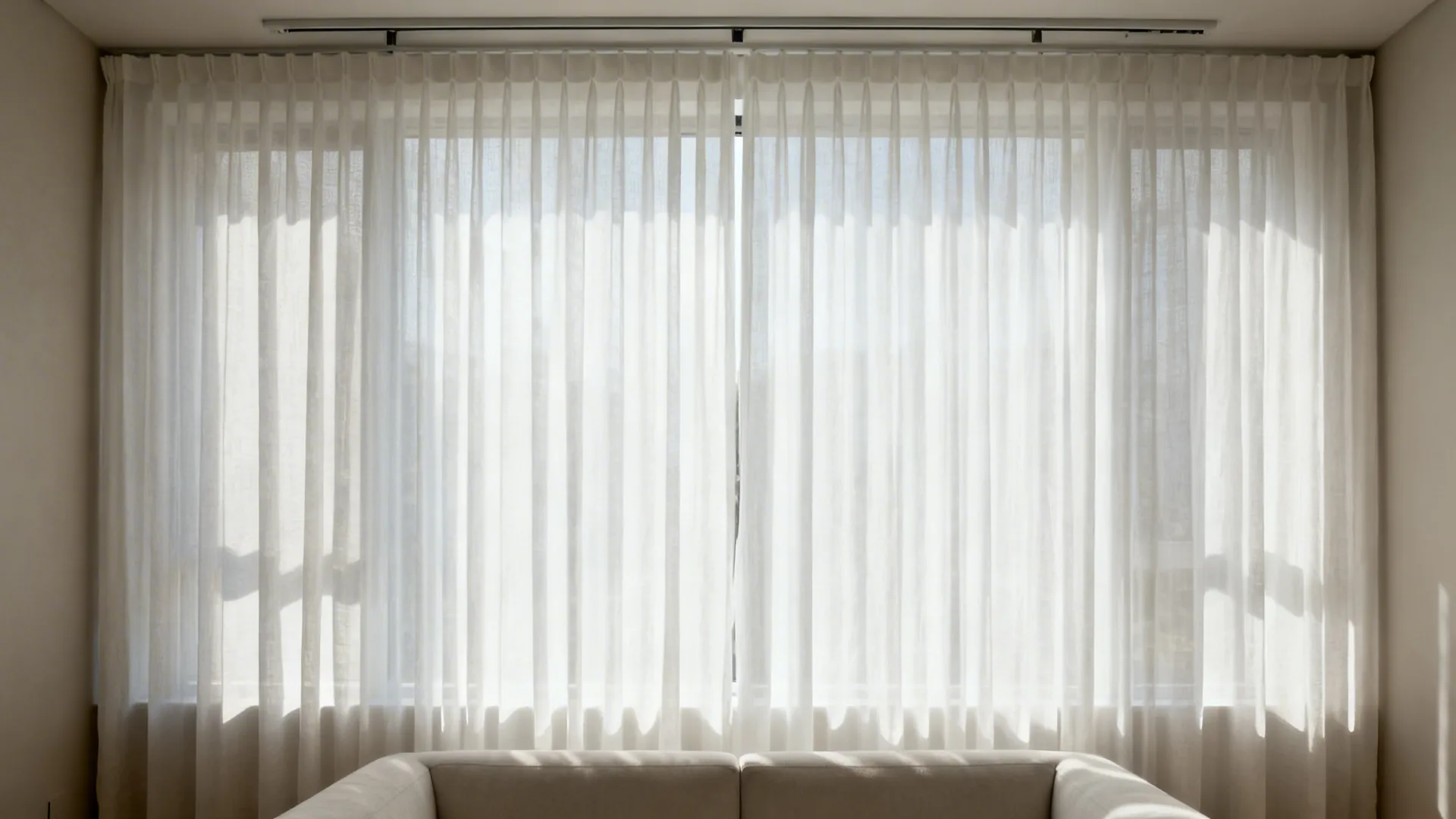 Floor-to-ceiling white sheers on a hidden track softly diffusing daylight in a living room