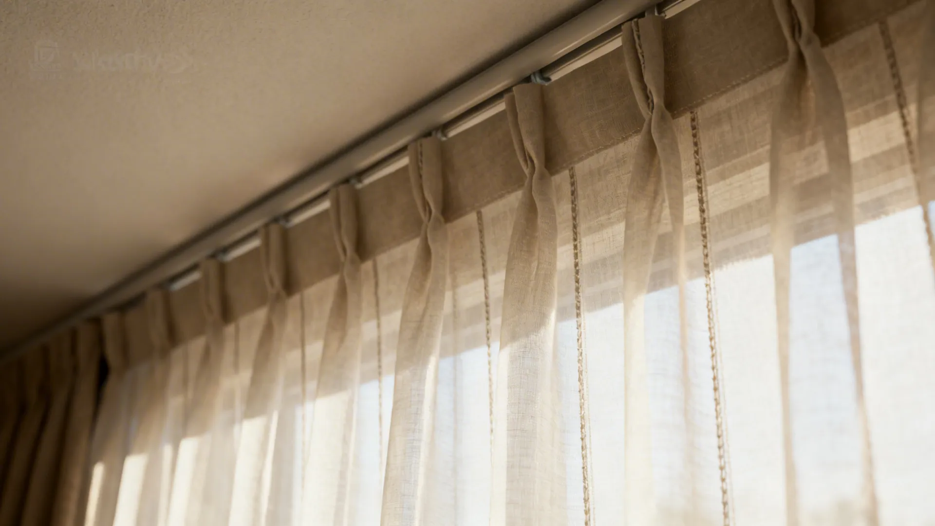 Close-up of sheer curtain fabric hung near the ceiling, soft vertical folds and backlit glow.