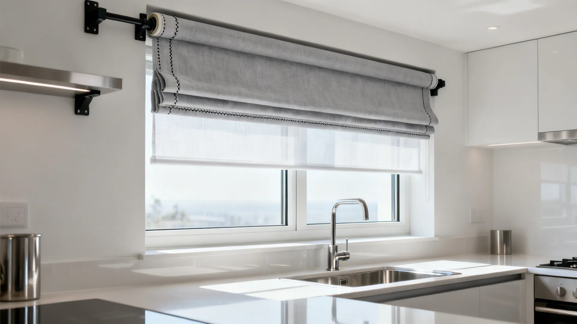 Micro-loft kitchen with a sheer roller shade and soft valance in neutral tones.
