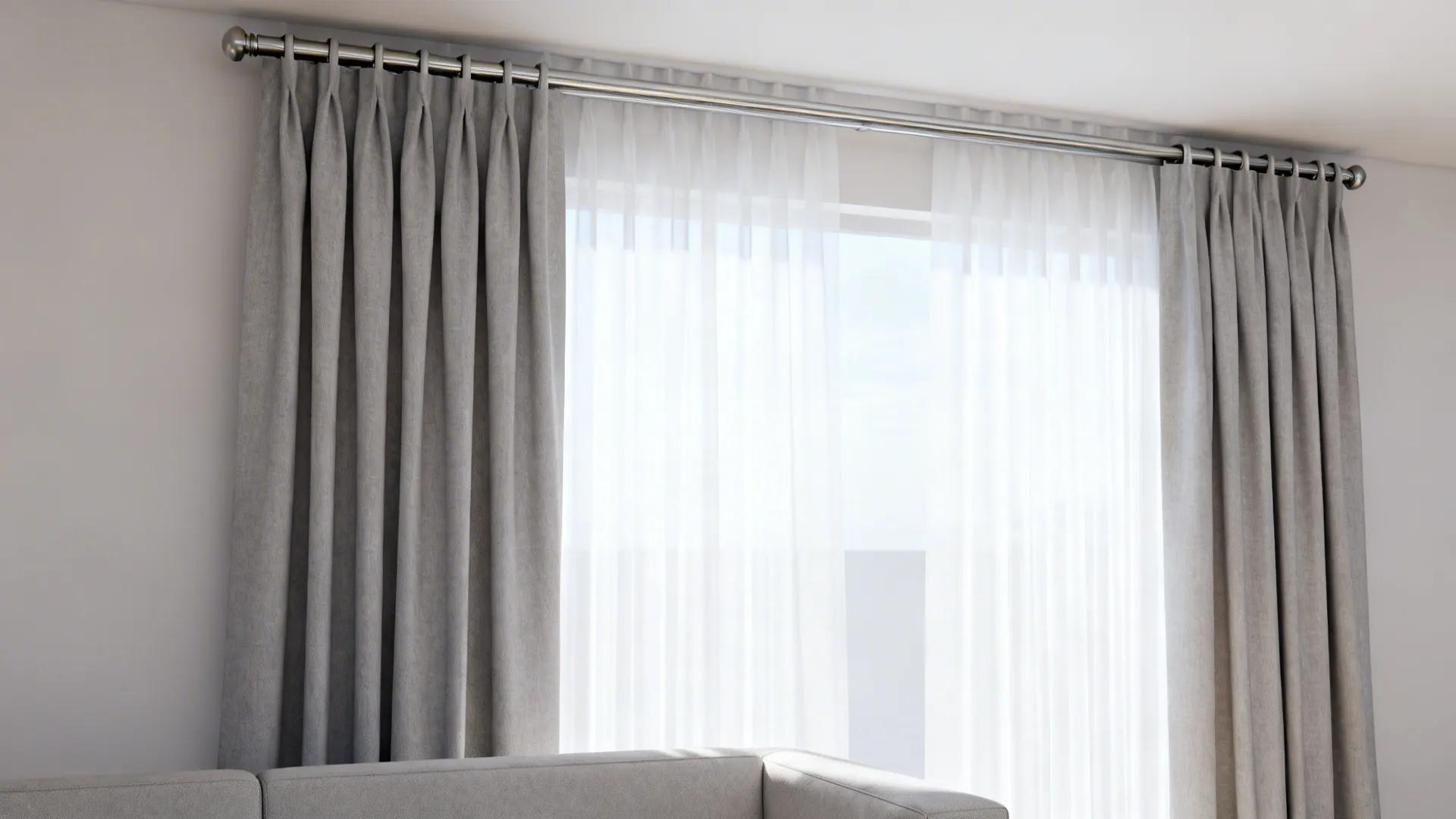 Close up of gray and white curtains hanging on a metal rod above a sofa