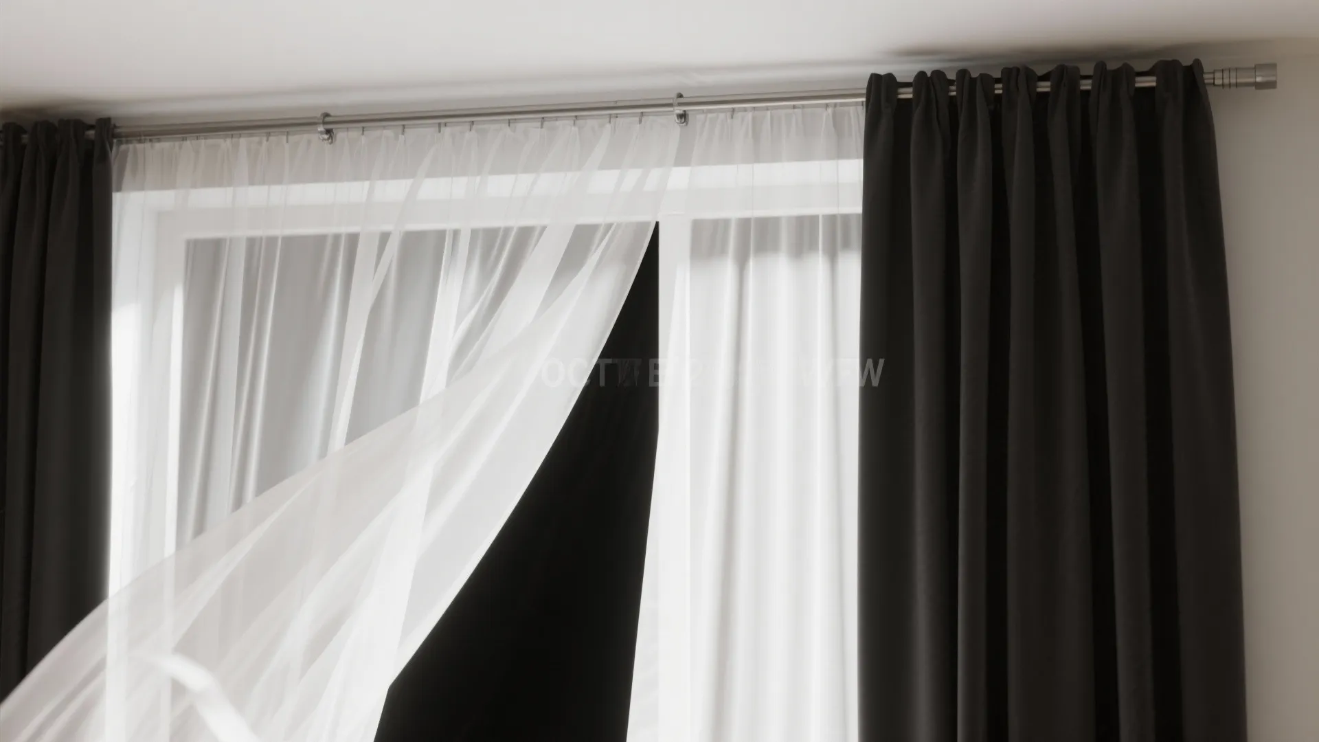 Layered white sheer and black blackout curtains demonstrating translucency and full light blocking