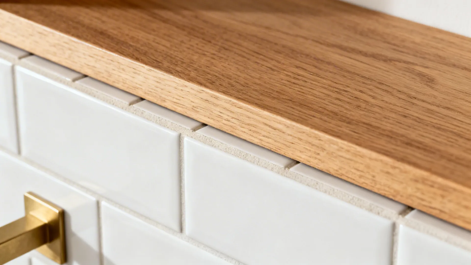 Macro of oak shelf aligned precisely with a tile grout line above a matte backsplash.