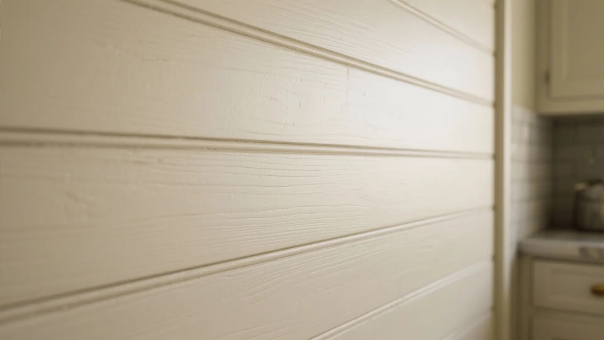 Close up view of light beige horizontal wall panel design in a bright kitchen setting