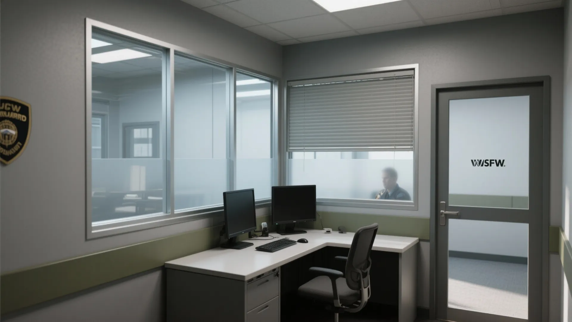 Security office room layout with glass windows black swivel chair grey desk and two computer screens