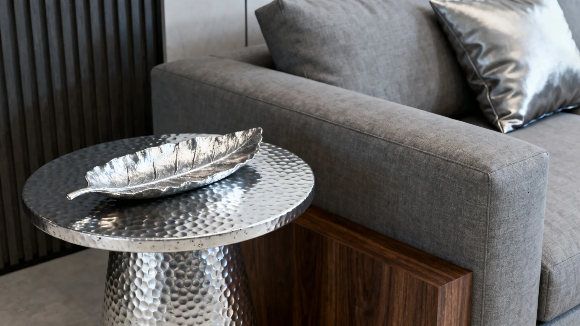 Hammered metal side table and pewter cushions creating a cool contemporary tone with wood accent.
