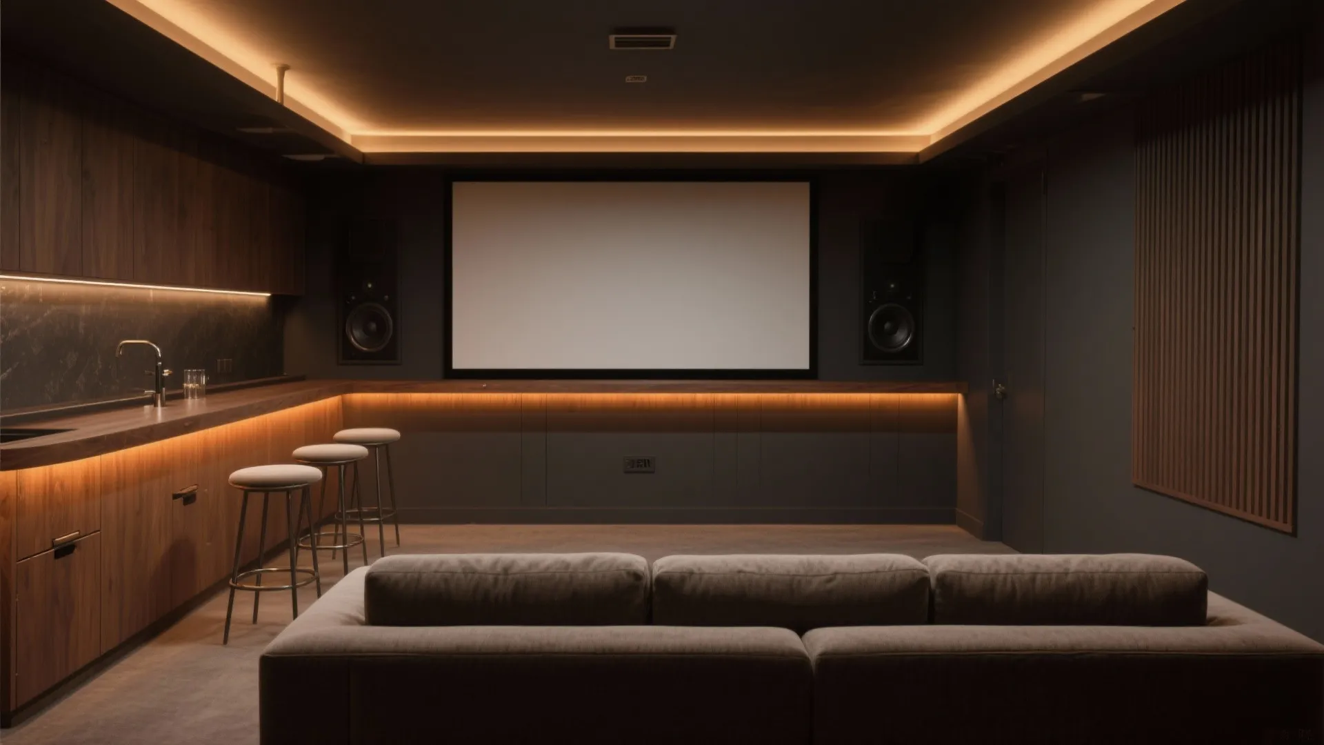 Home theater with large screen dark walls grey sofa bar stools and warm hidden lighting