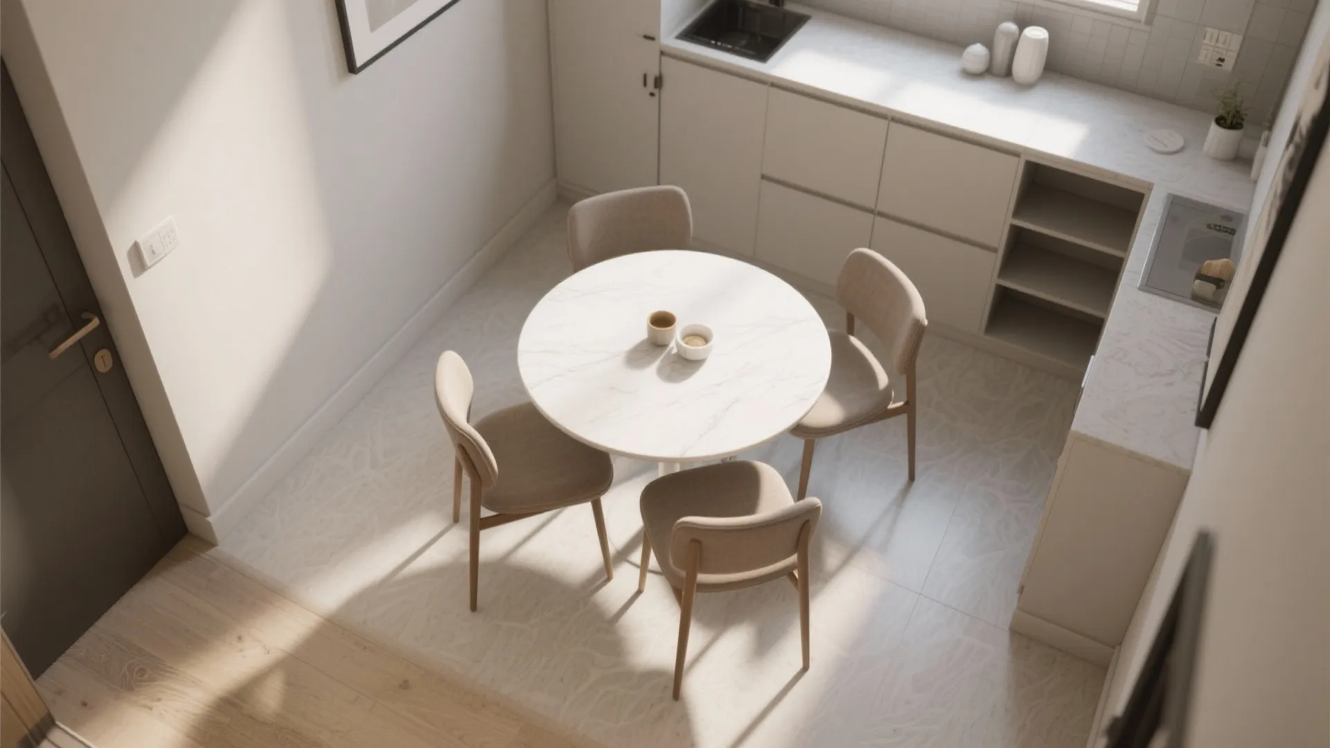 Top view of a small kitchen area with round dining table and four grey chairs