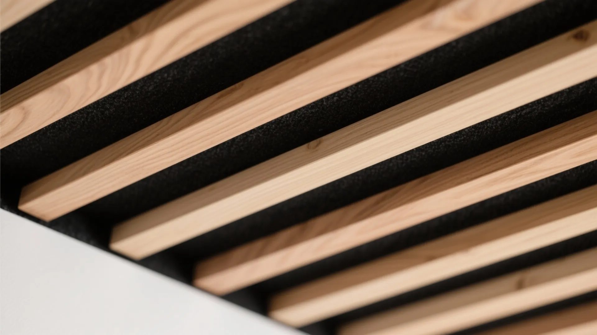 Close up view of wooden ceiling wall panel with black acoustic felt for modern interior design