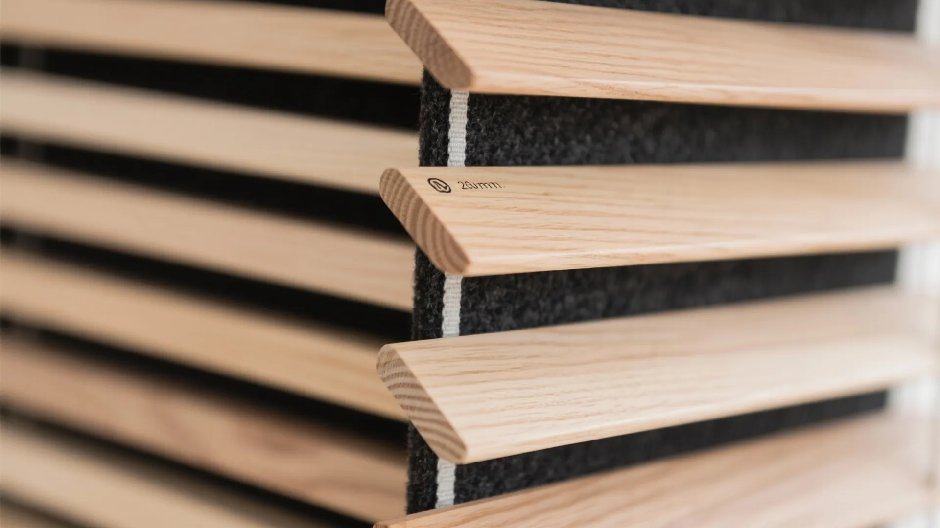 Close up view of wooden wall panel slats with black felt backing and simple texture