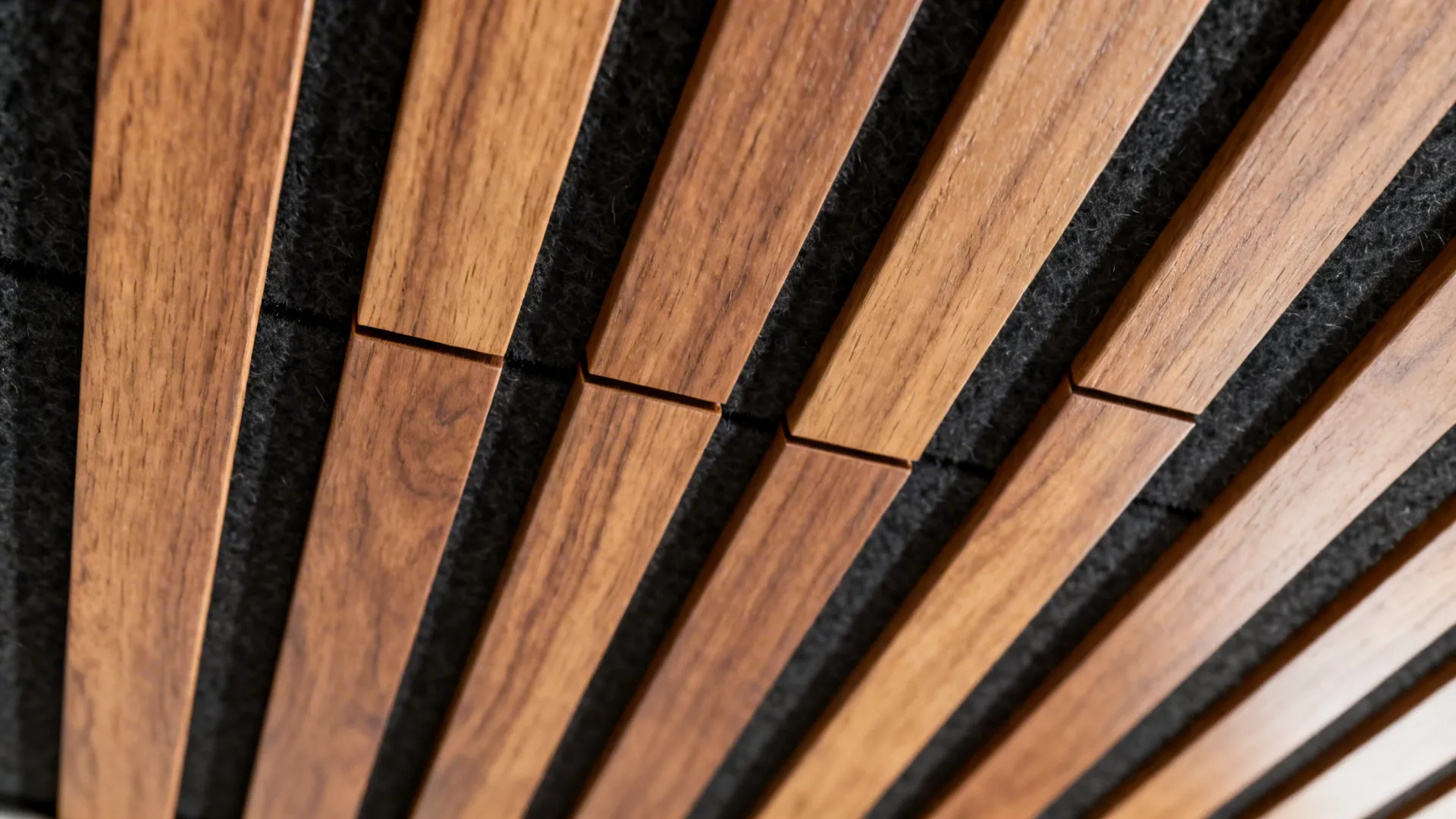 Close-up of oak slats with even spacing over black acoustic felt and a clean shadow gap.