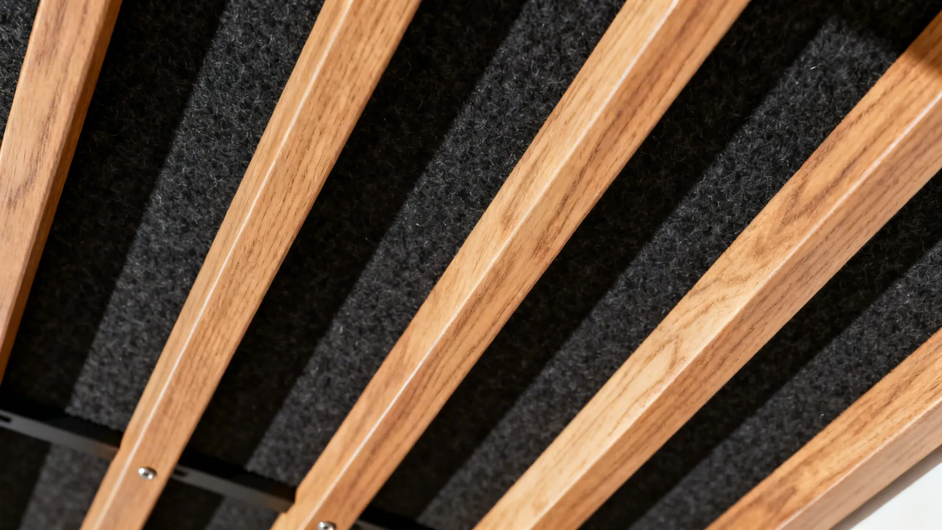 Close-up of oak slats with black felt backing showing fine grain and precise spacing.