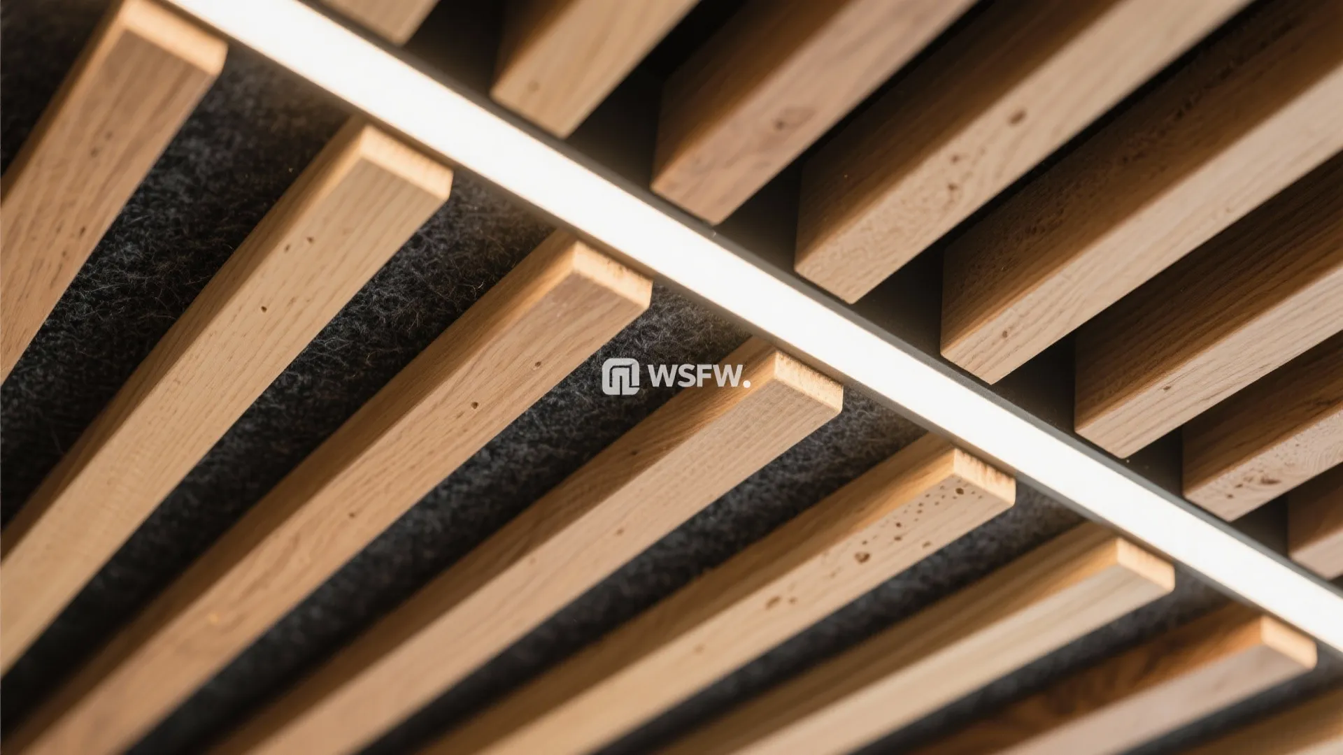 Close up view of wooden ceiling slats with integrated linear light fixture and grey acoustic material