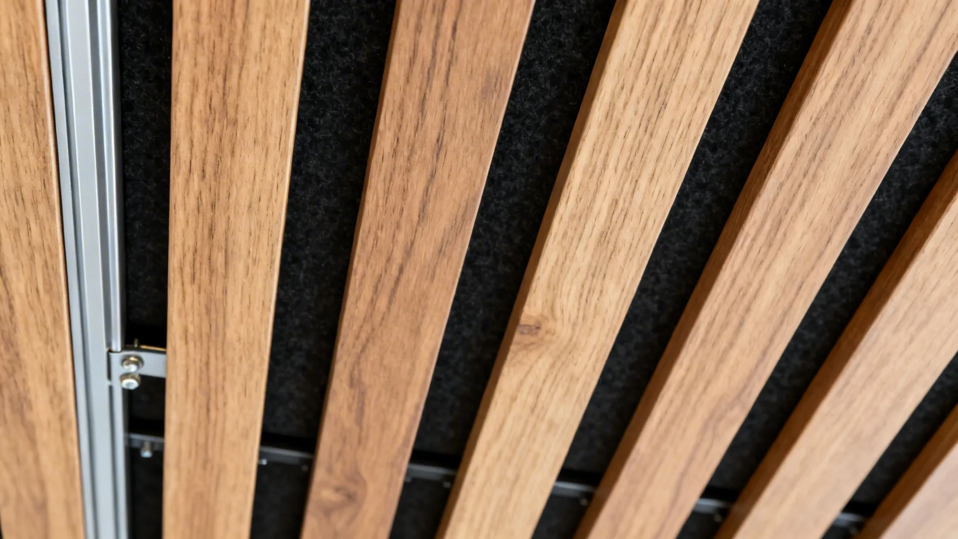 Macro detail of faux-wood slat with black acoustic backing and precise spacing.