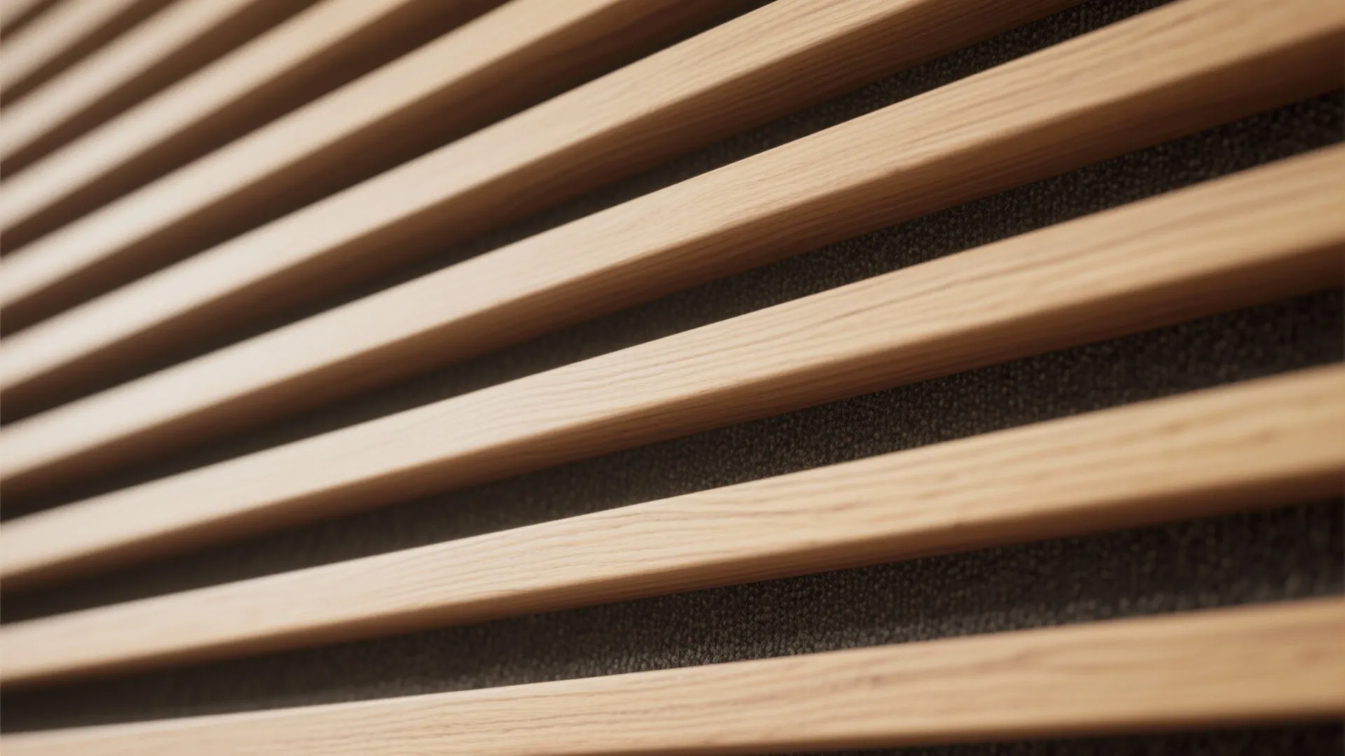 Close up view of horizontal wooden wall panel slats over a dark textured background material
