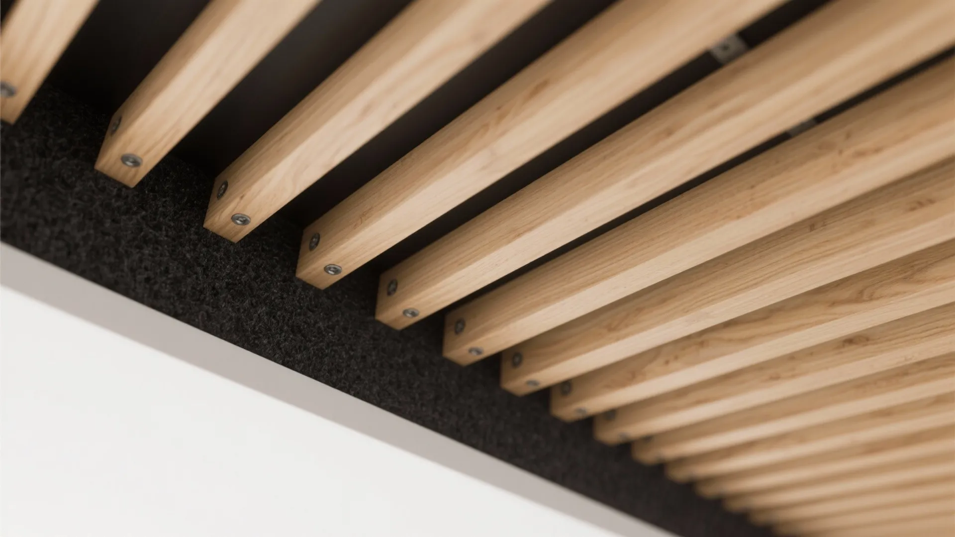 Close-up view of parallel light wooden slats installed on a dark background for modern ceiling