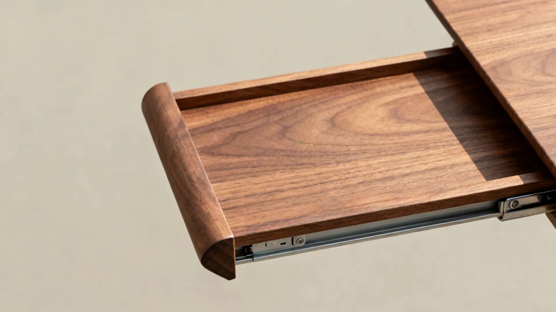 Macro of slide-out walnut slab with rounded edge and concealed hardware.