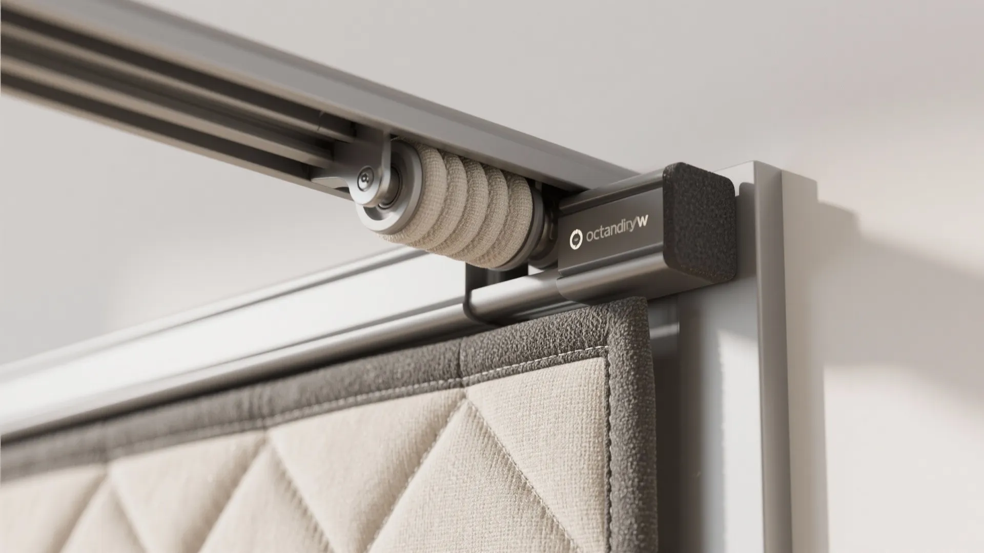 Metal sliding track system for a curtain showing a rolling mechanism and beige quilted fabric