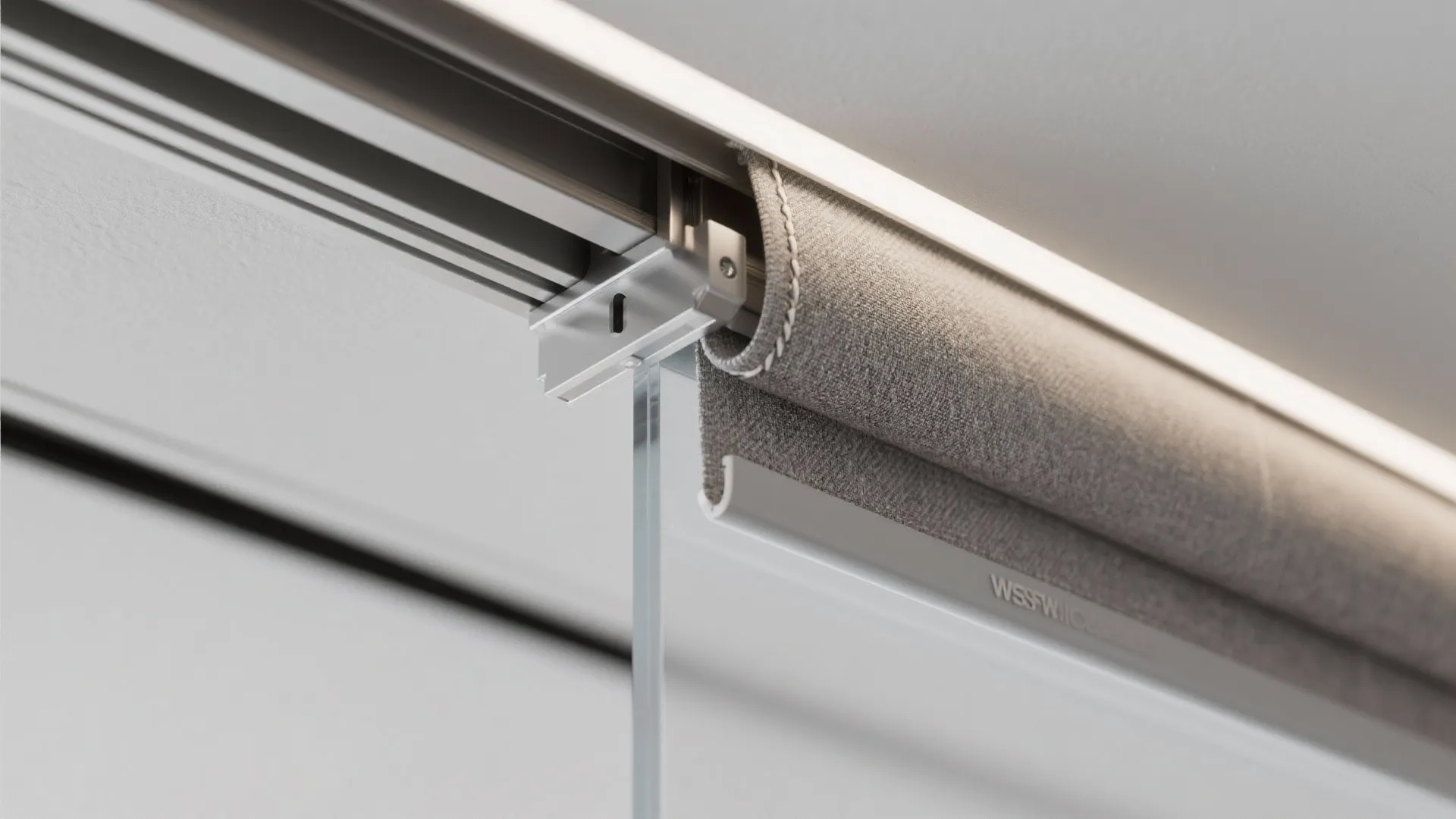 Close up of a metal sliding track system for a grey fabric curtain and glass