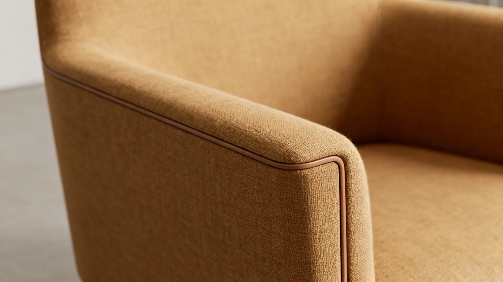 Macro view of slim upholstered armchair arm and fabric texture in camel color