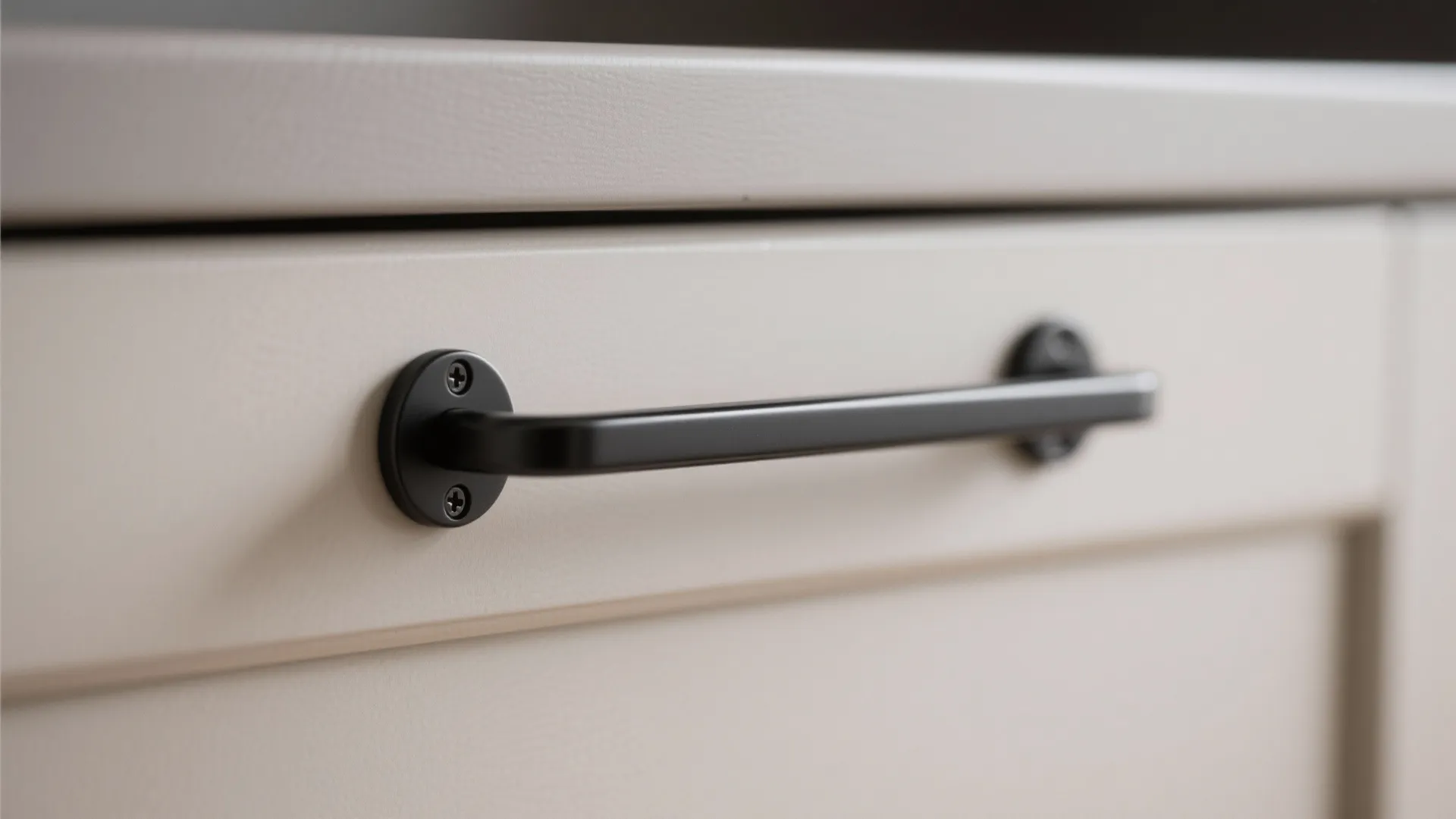 Modern matte black slim bar handle installed on a white kitchen drawer with clean simple lines