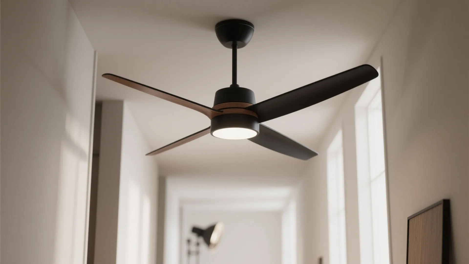 Modern black ceiling light fan with four wood blades installed in a bright hallway interior