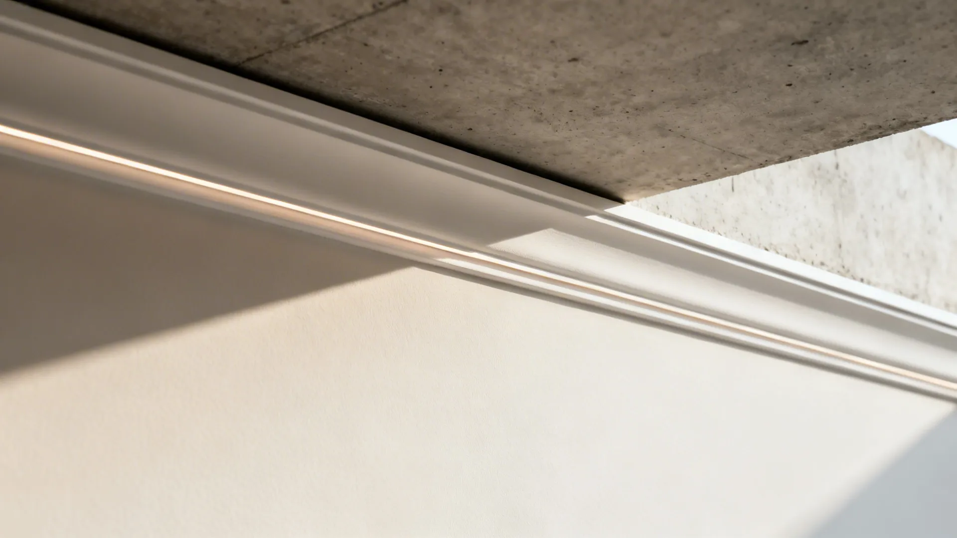 Macro of slim crown molding and a precise 10 mm shadow gap under the slab.