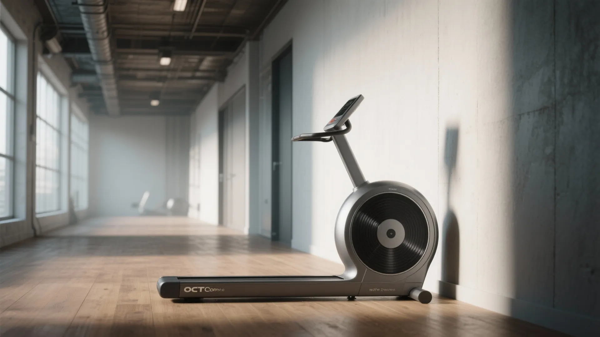 Modern grey elliptical machine standing on wooden floor in a bright sunlit hallway room interior