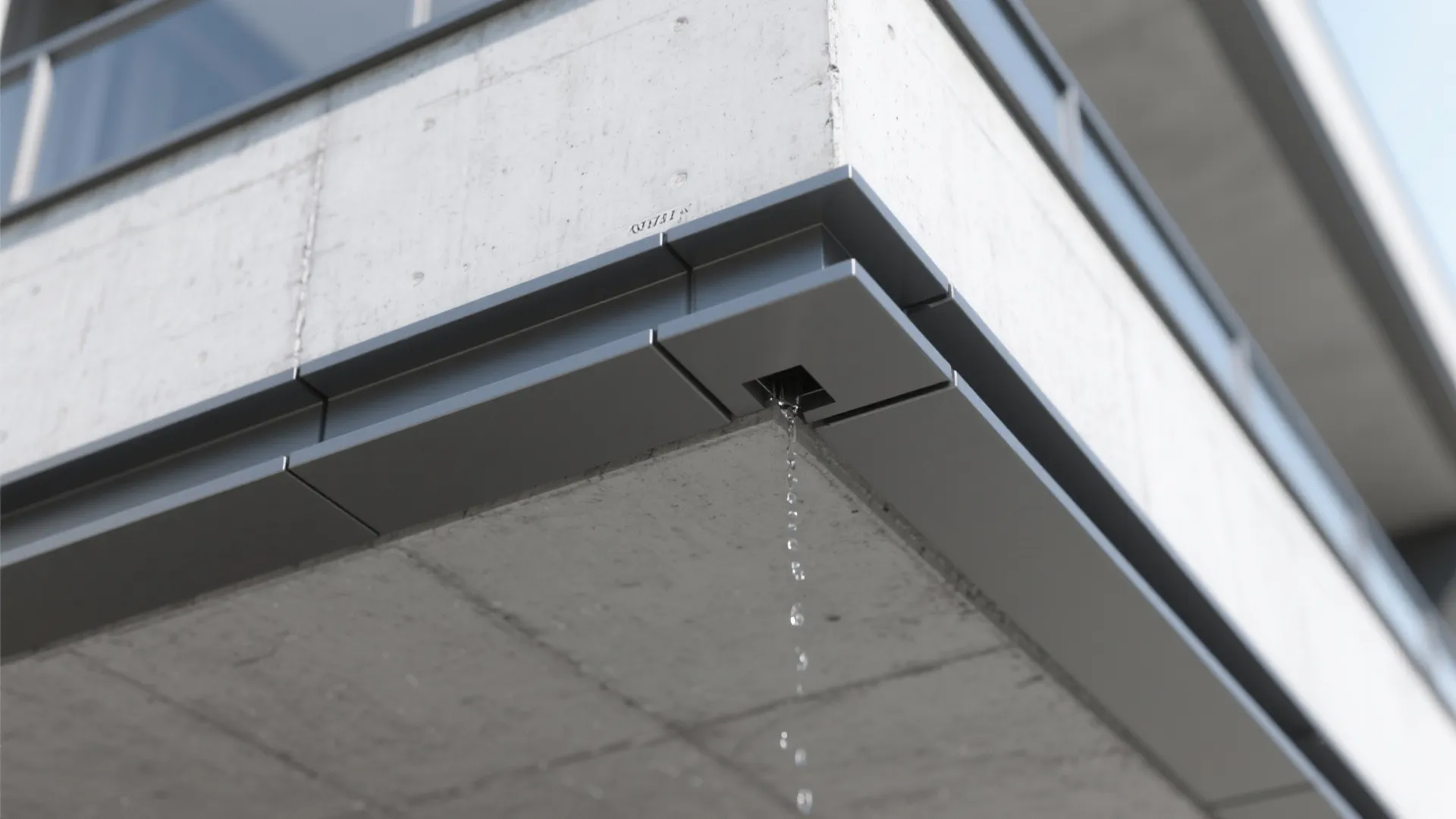 Modern concrete balcony with grey metal edge detailing and small water drainage hole from below