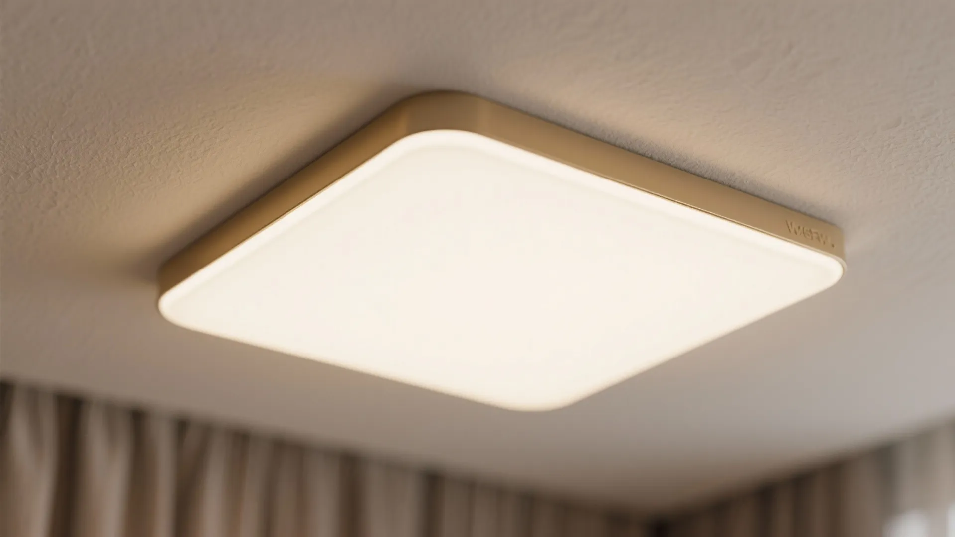 Close up of a square white ceiling light fixture with a gold frame near beige curtain