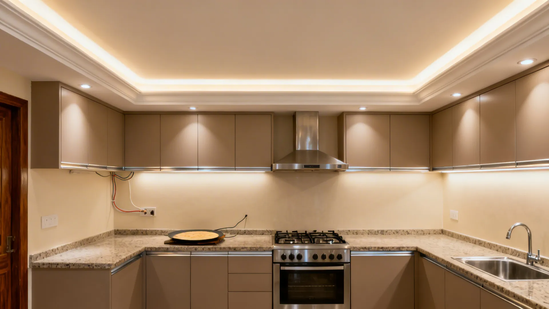 Slim gypsum tray ceiling with warm cove lights and task spots in a small Indian kitchen.