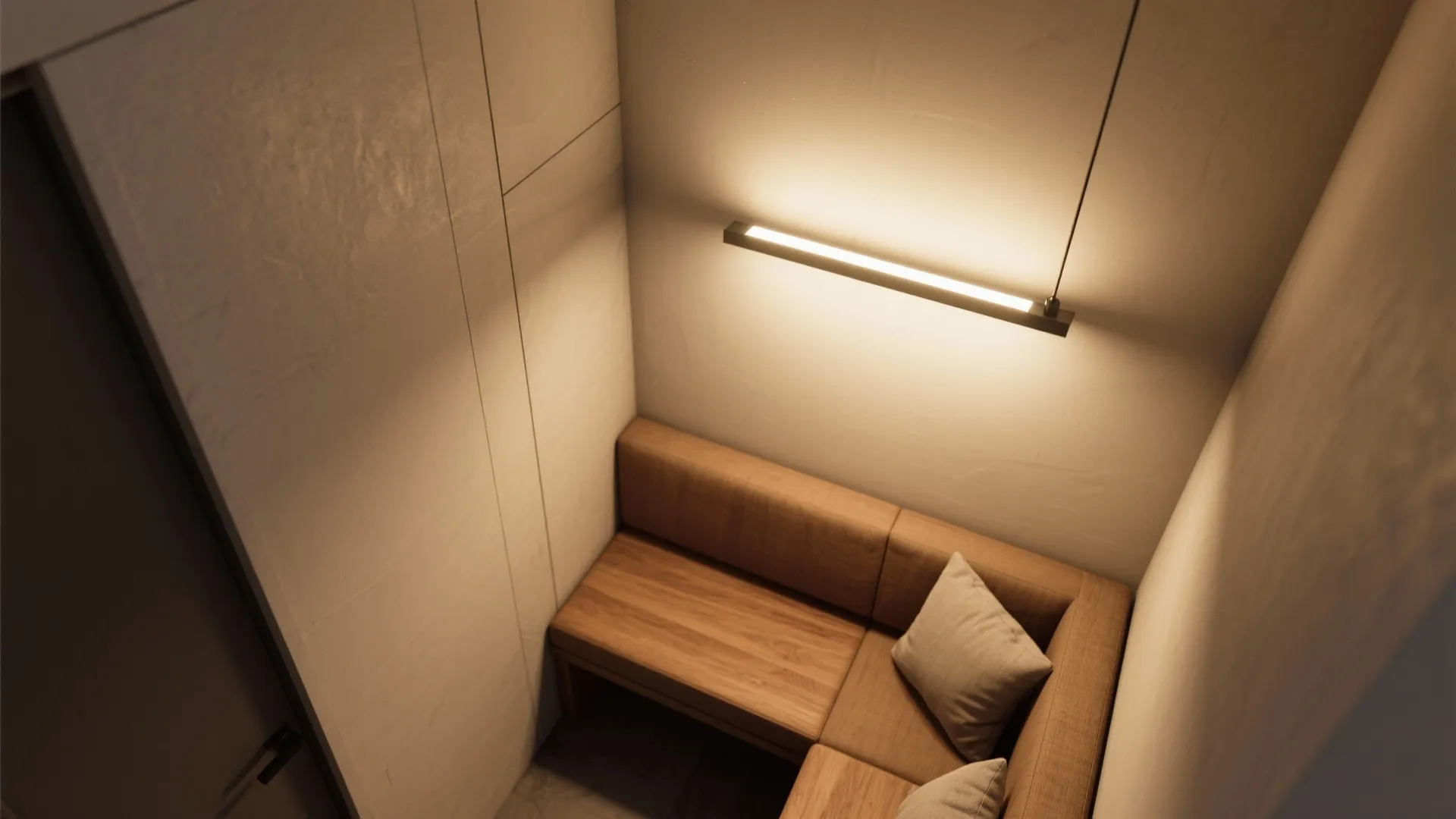 Slim-profile LED pendant lighting a built-in seating nook in a tight space with warm light