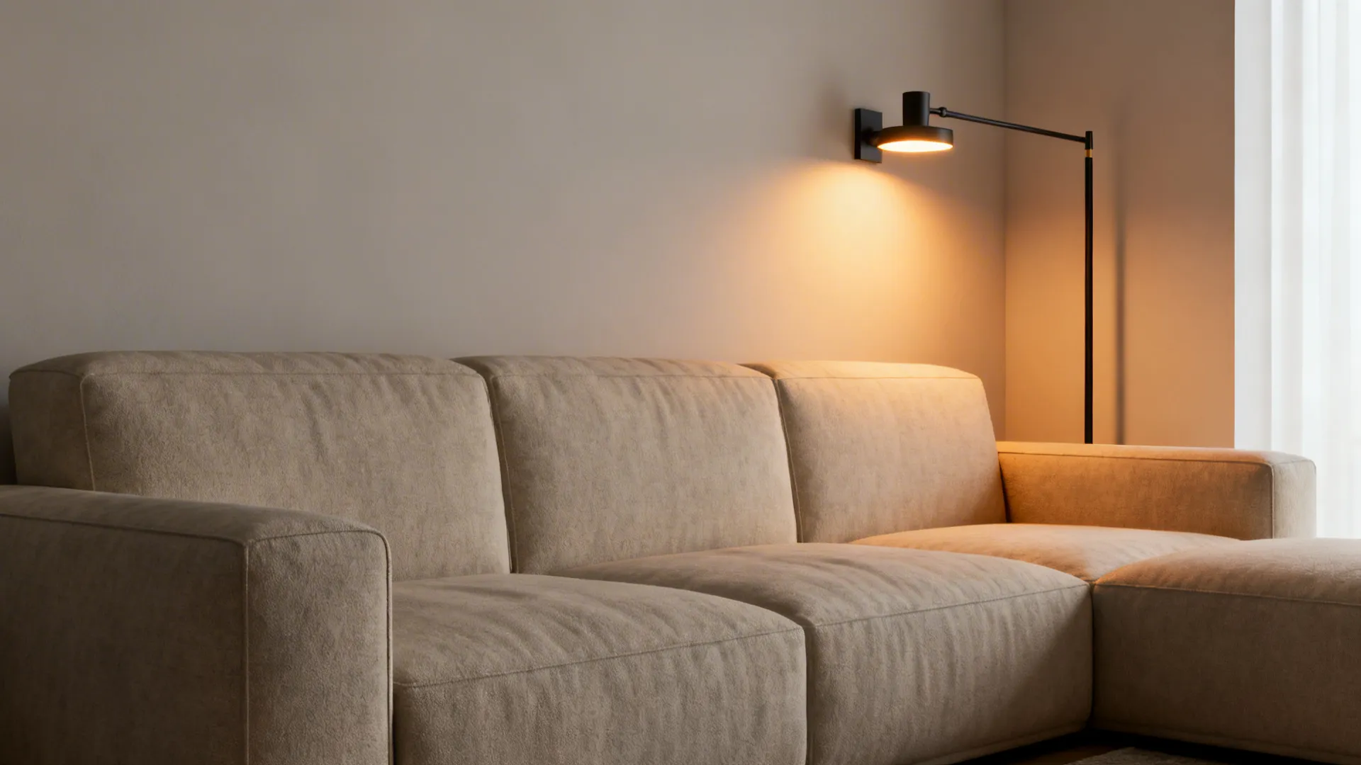 Slim floor lamp and wall swing-arm light paired with a large sofa to reduce visual mass.