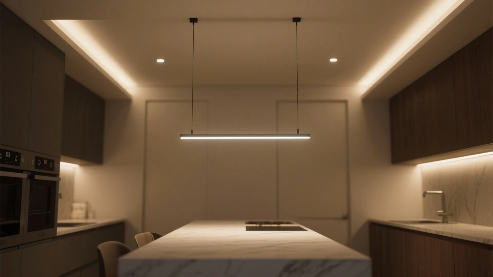 Modern kitchen island with a slim linear ceiling light hanging above a white marble countertop