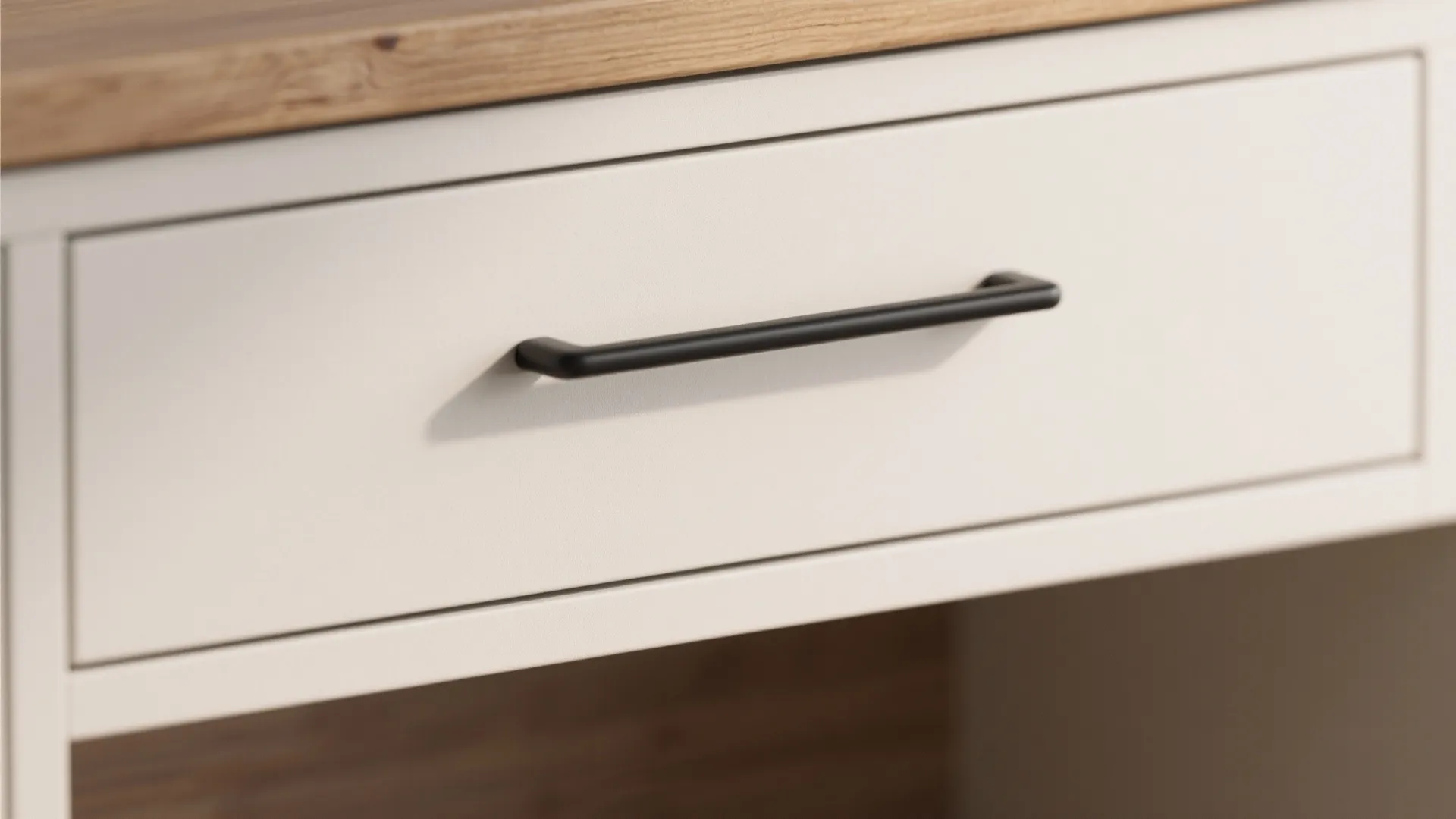 Close-up of slim matte black bar pull on a light flat-panel drawer