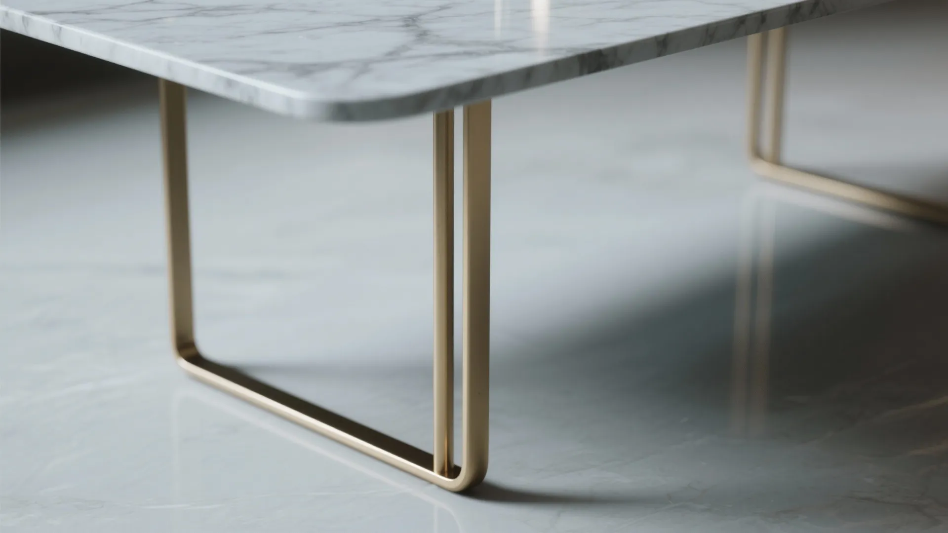 Close up of a marble coffee table with slim gold metal legs on white tile floor