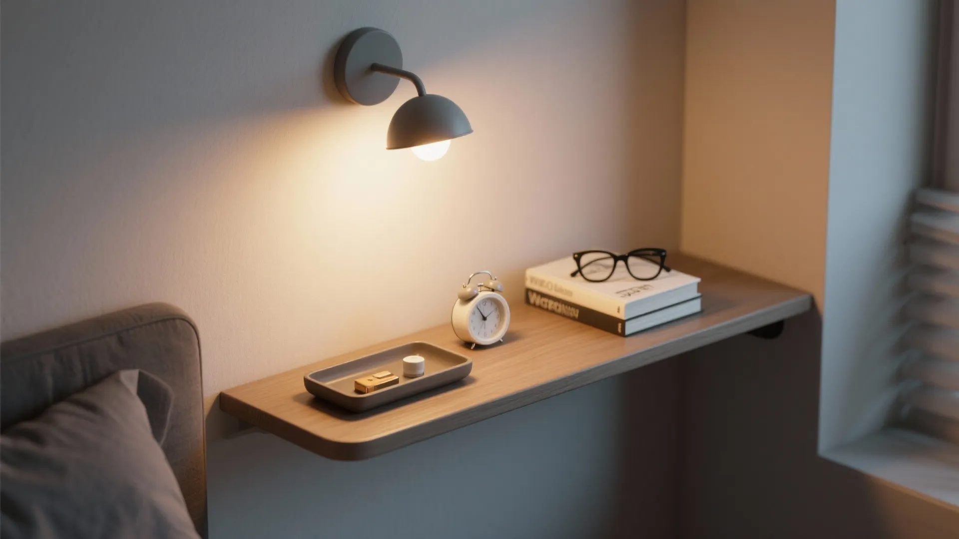 Small wall shelf with clock and books under a wall light in a cozy bedroom corner