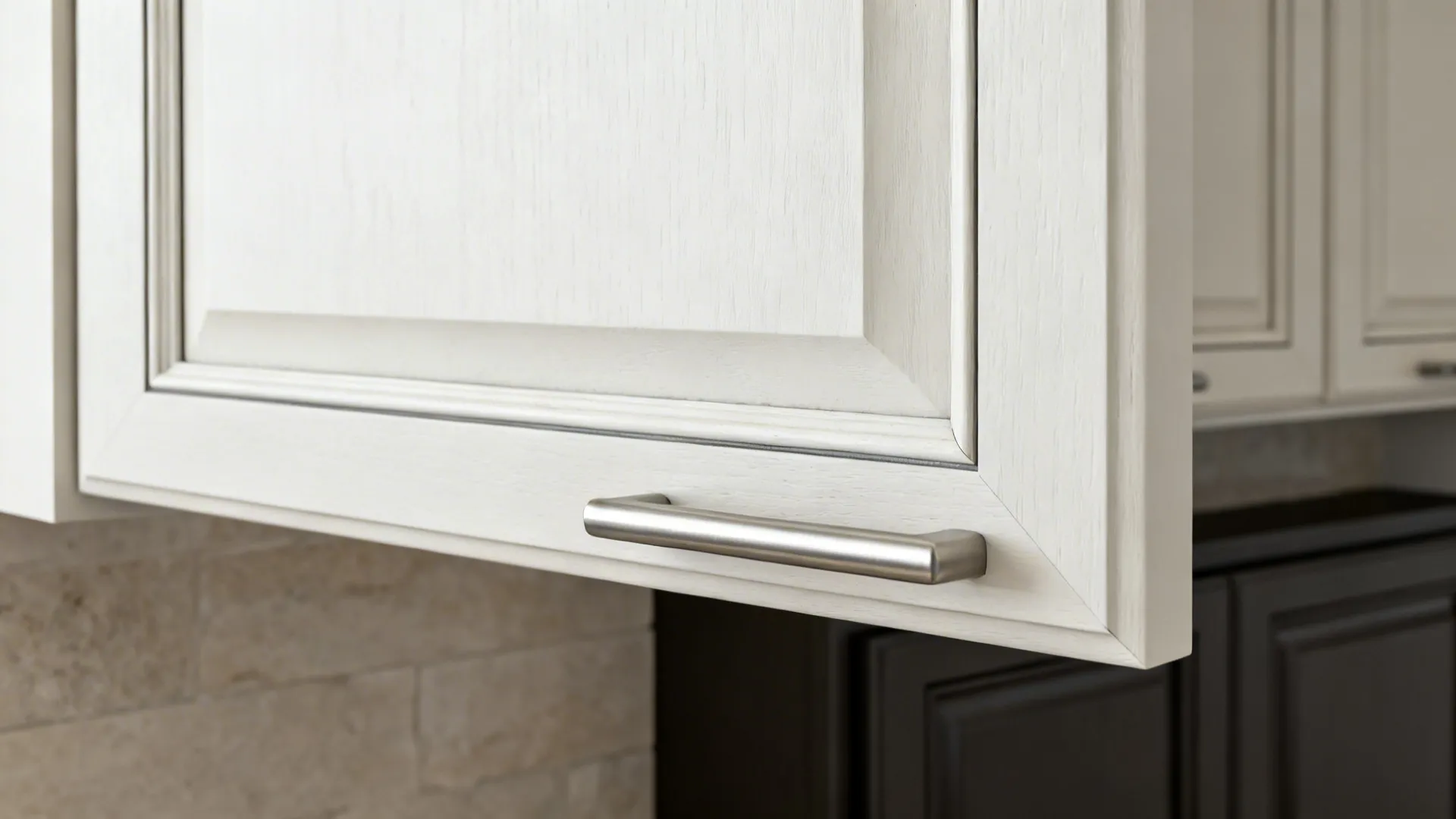 Close-up of a slim Shaker upper cabinet door with narrow rails and a sleek pull.
