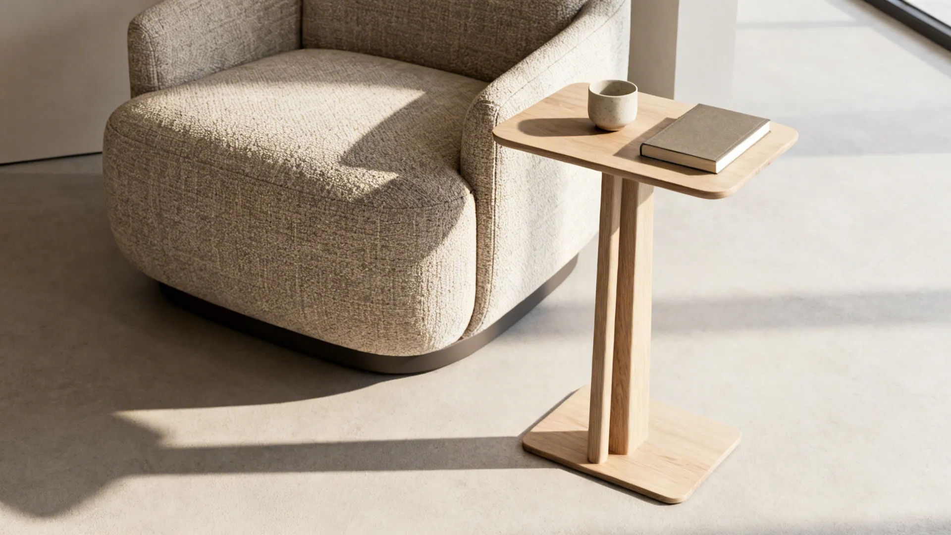 Slim tall side table beside an oversized chair showing functional scale without visual bulk.