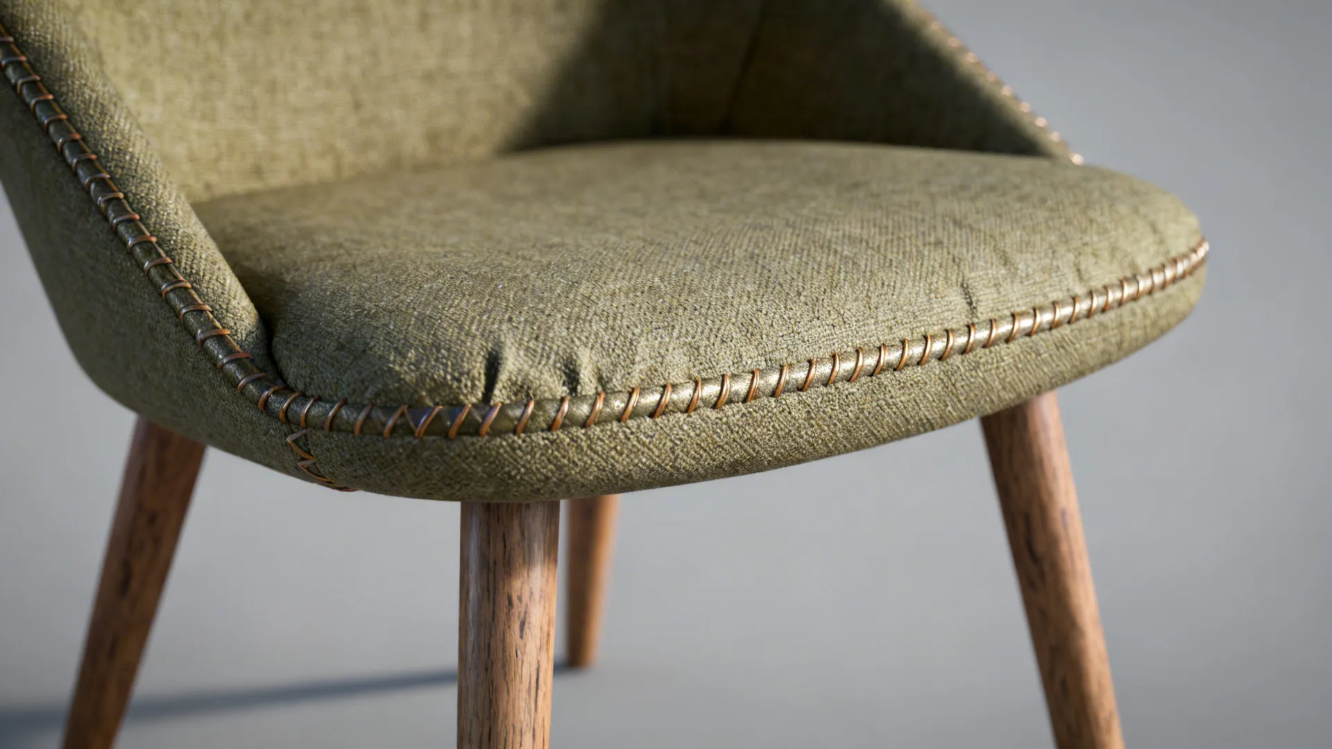 Close-up of a mid-century accent chair showing slim frame and exposed wooden legs with textured upholstery.