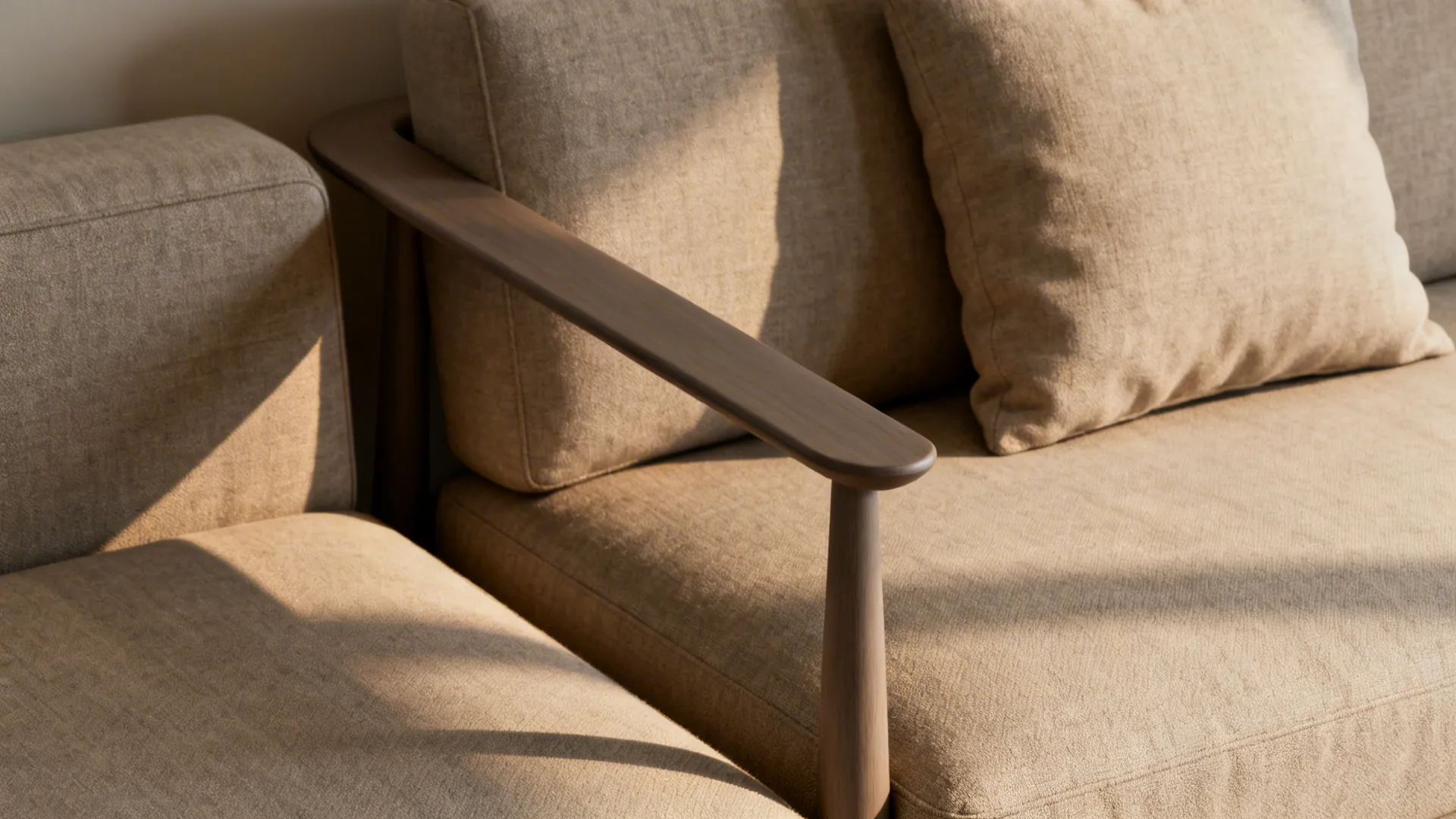 Close-up of a slim-profile sofa with tapered arms and an armless loveseat with a lumbar cushion.
