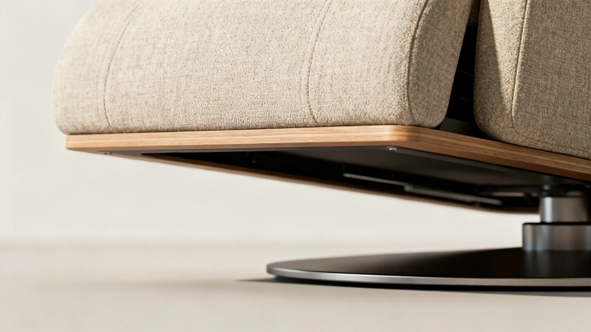 Close-up of slim swivel recliner raised base showing space for vacuuming and fabric texture.