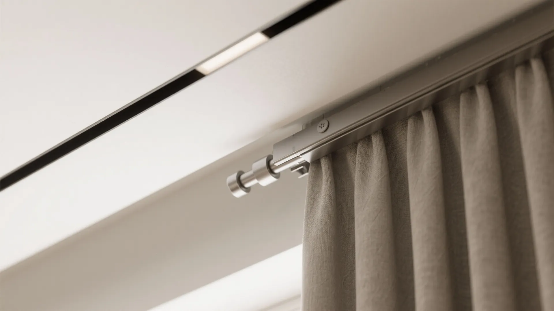 Close up view of a modern silver metal curtain rail and fabric hanging from ceiling