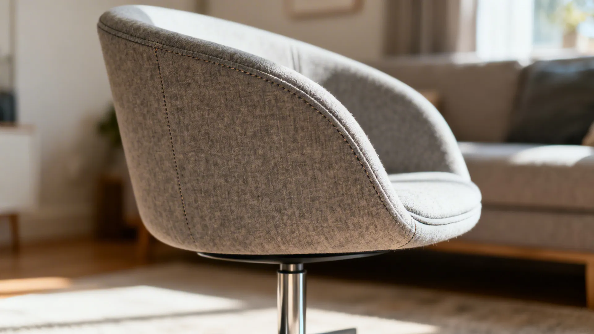 Close-up of a slim-profile swivel tub chair showing curved back and slim base in soft daylight.