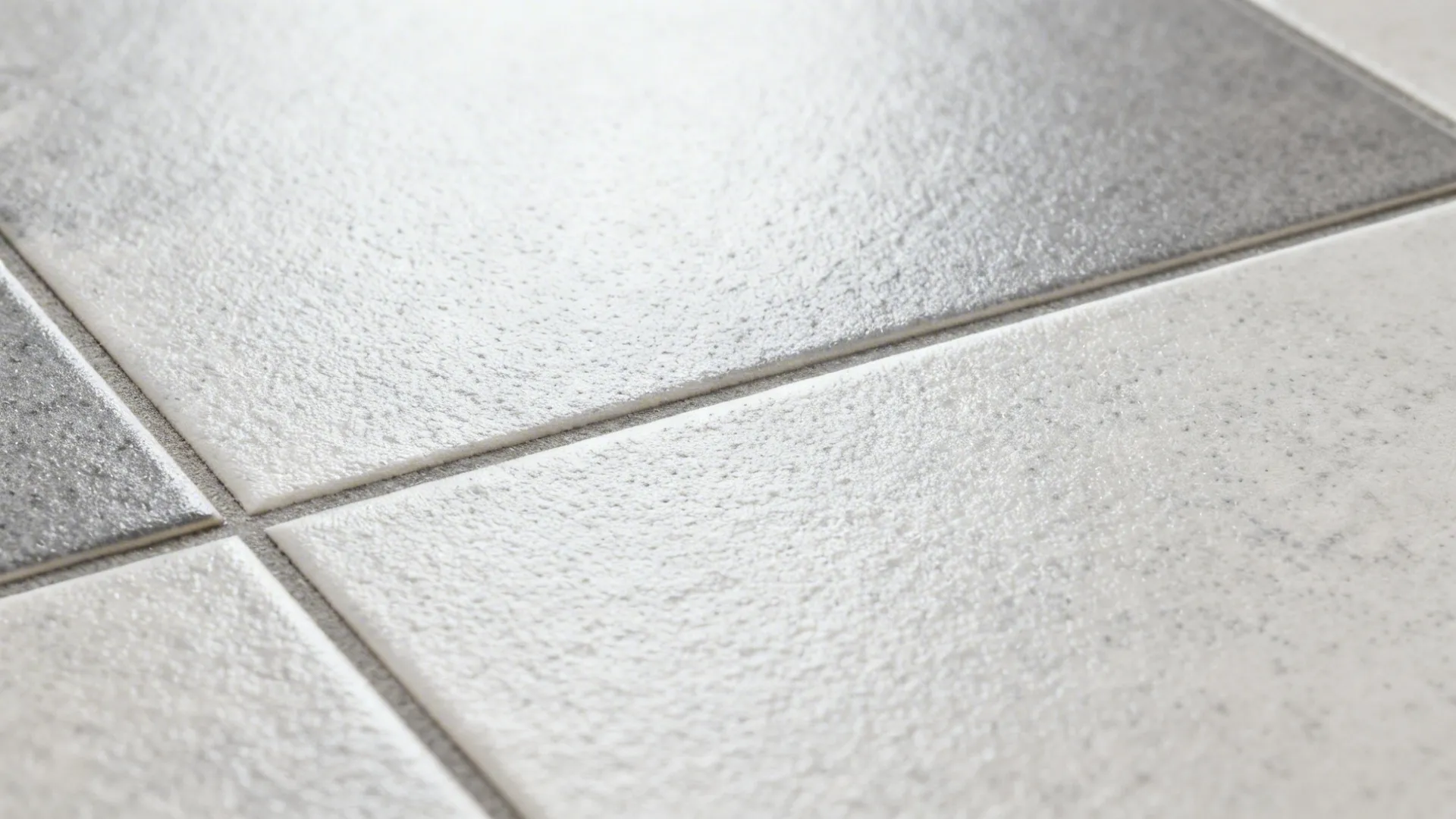 Macro of micro-textured slip-resistant porcelain tile with color-matched grout in soft daylight.