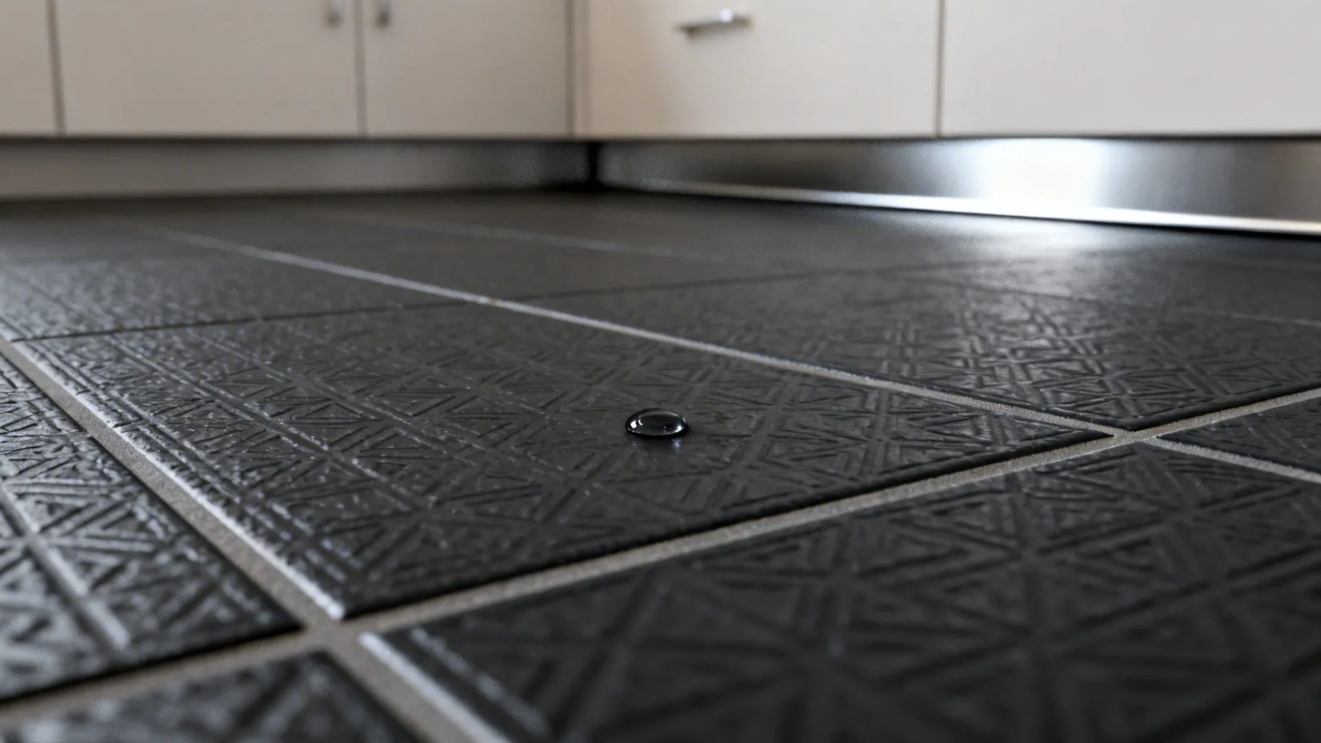 Macro view of slip-resistant black tile with micro-texture and charcoal grout in soft daylight.